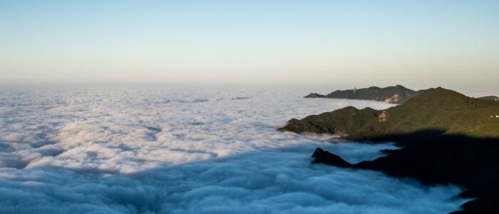 a view of some mountains and clouds in the sky